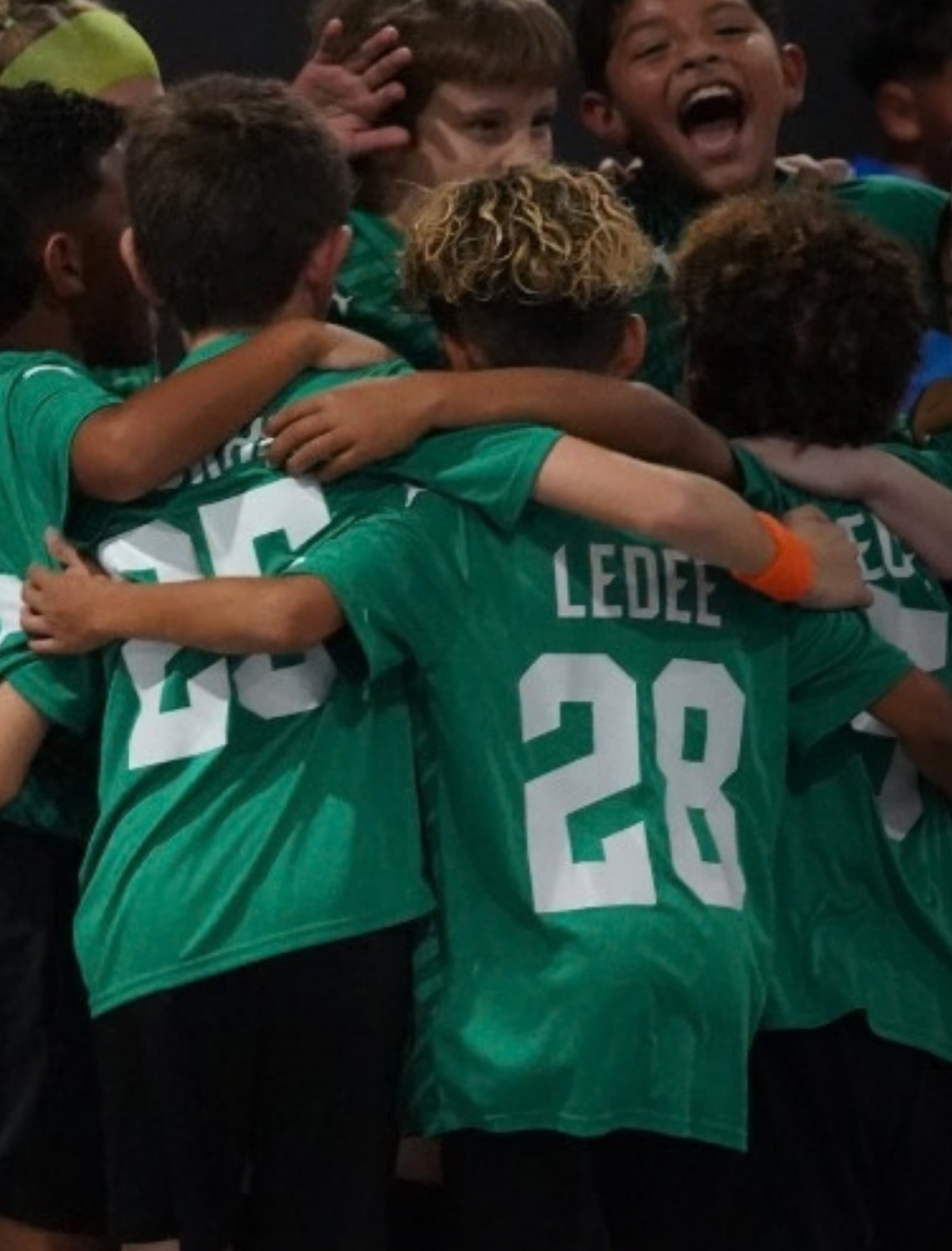 Youth futsal team celebrating together